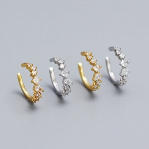 Macro shot of silver and gold S925 ear clips with inlaid cubic zirconia in various shapes
