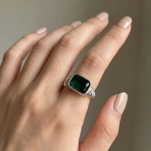 Detail of twisted cable texture ring with a large emerald-cut dark green gemstone