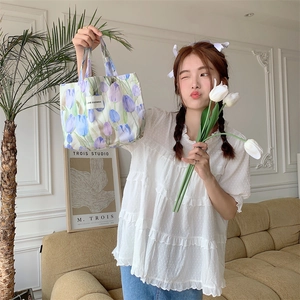 Détail du sac en toile à motif de tulipes avec étiquette de marque et texture du tissu