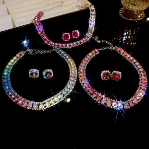 Detailed view of colorful gradient crystal necklace and earring sets on mirror base