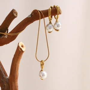 18K gold plated necklace and pearl earrings set displayed on a rustic branch