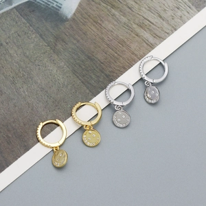 Detail of gold and silver sterling silver hoop earrings with sparkling zircon smiley pendants