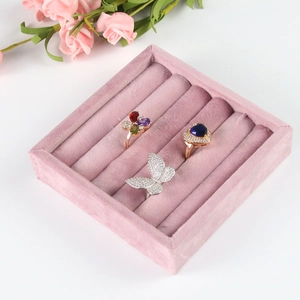 Detailed view of pink velvet ring box organizer with silver and gold jewelry samples