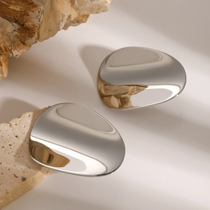 Macro shot of silver concave geometric stud earring with liquid metal texture on stone