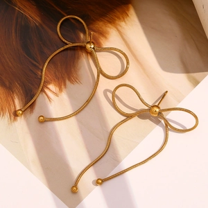 Gros plan sur des boucles d'oreilles papillon dorées avec texture chaîne serpent