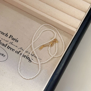 Macro shot of fine 925 silver pearl necklace in a cream jewelry box with gold clasp