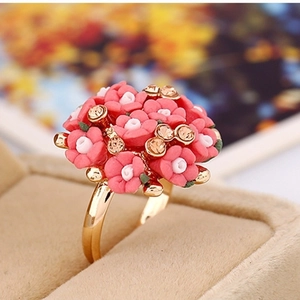 Macro shot of elegant rose cluster ring with ceramic flowers and amber rhinestones