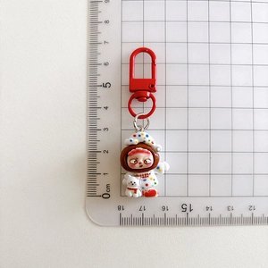 Cartoon keychain pendant measurement showing 7cm length on a white grid cutting mat