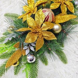 Christmas garland decoration with gold sequin flowers and green pine needles on white fur