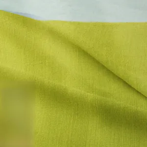 Close-up of grass green woven tapestry fabric showing thick cotton linen texture