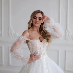Elegant white off-shoulder bridal gown with lace embroidery and sheer puffy sleeves