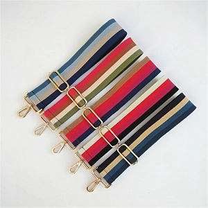Detail view of five thick adjustable woven cotton purse straps with gold metal hardware