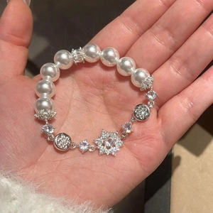Gros plan d'un élégant bracelet de perles et fleurs en cristal porté à la main pour femme