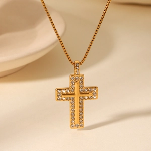 Close-up of a sparkling 18K gold plated cross pendant with cubic zirconia on a box chain