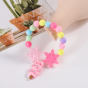 Colorful beaded kids bracelet with pink rabbit and snowflake charms on display