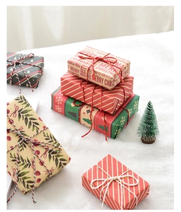 Close-up of Christmas gift box set with festive patterns on white plush background