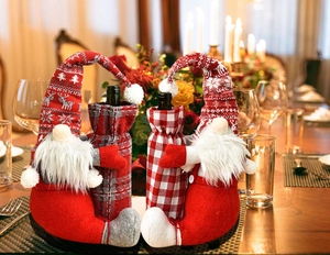 Detail of Christmas gnome wine bottle covers with knitted reindeer hats and plush beards