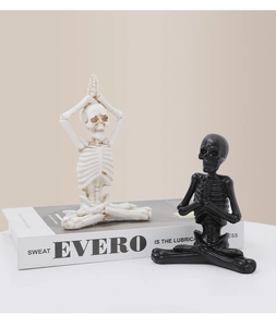 Détail de figurines de squelettes de yoga en résine noir et blanc pour décoration gothique