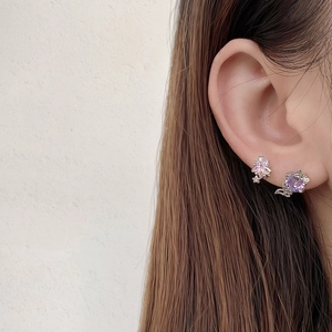 Close-up of pink star and purple butterfly wing stud earrings with 18k gold zircon