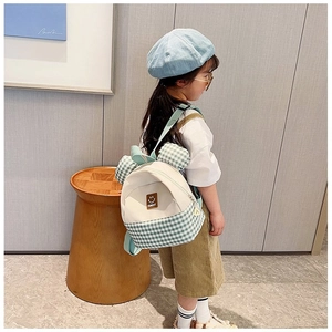 Detail view of children's checkered backpack with cute ears and Sunday logo on kid model