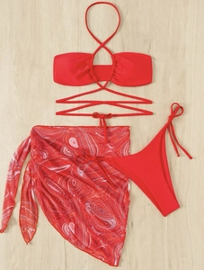 Flat lay of a red three-piece bikini set with a marble print mesh beach sarong skirt