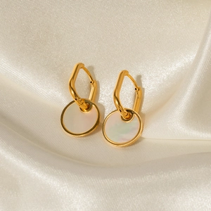 Golden titanium steel earrings with white mother-of-pearl pendants on silk fabric