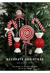 Close-up of red and white candy cane ornaments with glitter on a Christmas tree