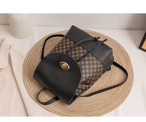 Detail of vintage mini backpack showing golden oval twist lock and drawstring closure