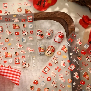 Macro shot of red festive nail stickers featuring cartoon pony and holiday motifs TL-454