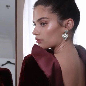 Polished silver double heart stainless steel stud earrings on model with velvet dress