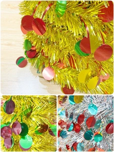 Close-up of gold and silver tinsel Christmas trees with shiny round colorful sequins