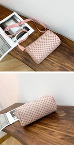 Close-up of pink barrel shoulder bag with brown interlocking pattern and nylon strap