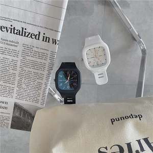Flat lay of square white and black silicone watches on a vintage newspaper background