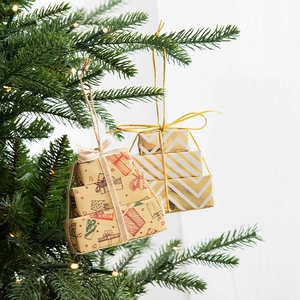 Mini Christmas gift box ornaments hanging on tree branch for festive holiday decor