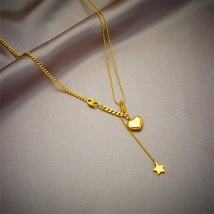 Golden necklace with heart pendant and star tassel on a mixed curb and bead chain