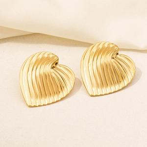 Macro detail of 18K gold plated heart earrings with elegant vertical pleated textures