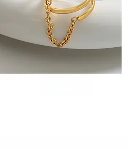 Macro shot of gold double-layer ring with delicate chain link detail on ceramic base