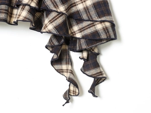 Detail of classic plaid fabric in brown and blue with ruffled edge and fine stitching