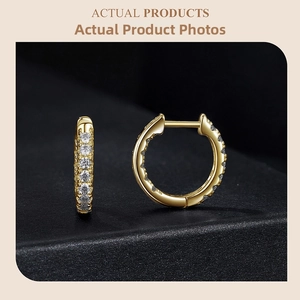 Macro shot of gold huggie earrings with brilliant cut sparkling cubic zirconia inlay