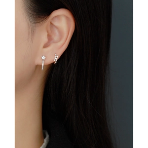 Detail of S925 sterling silver geometric diamond earrings worn by a model in close-up shot