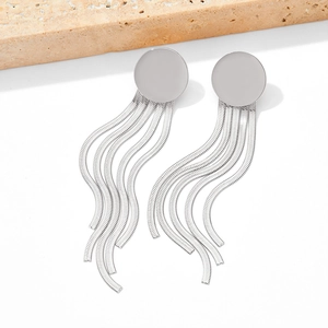 Detail of silver metallic tassel earrings with snake chains and round studs on stone