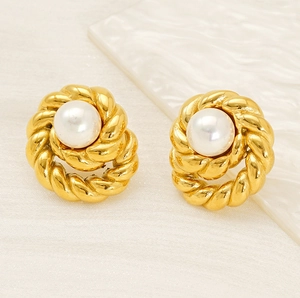 Detailed close-up of vintage pearl earrings with gold twisted rope texture and white stone