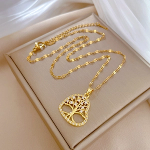 Macro detail of gold tree of life heart necklace on beige jewelry display box