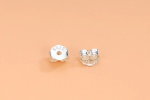 Detailed macro shot of 925 sterling silver butterfly earring backs with hallmarked stamps