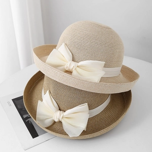 Detail van elegante strohoeden met grote witte chiffon strikken in natuurtinten