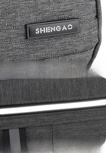 Macro view of grey textured polyester fabric with rubber logo and reflective safety strip