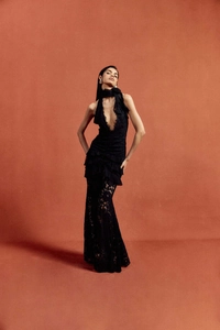 Detail of elegant black lace evening gown with intricate patterns and tiered skirt