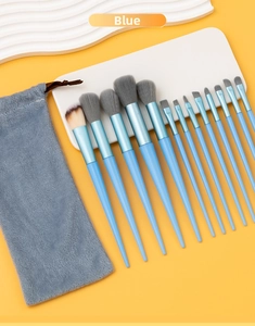 Detail of 13 professional blue makeup brushes with soft bristles and a plush drawstring bag