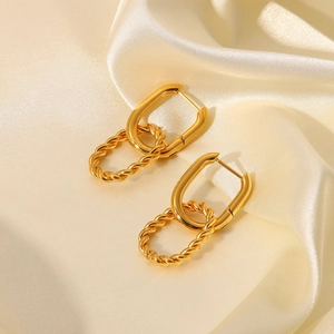 Macro detail of gold interlocking twisted rope rings on luxury cream silk fabric