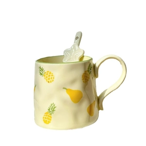 Cute large ceramic mug with fruit patterns and star-shaped spoon on white background